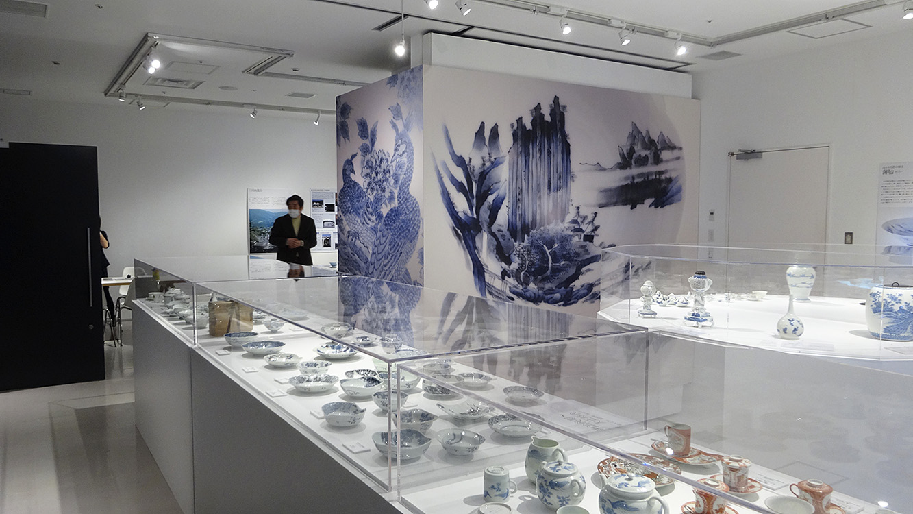 白い背景に青絵が映えるよう、色彩計画を調整。
みかわち焼の繊細な絵付けが際立つ展示デザイン。