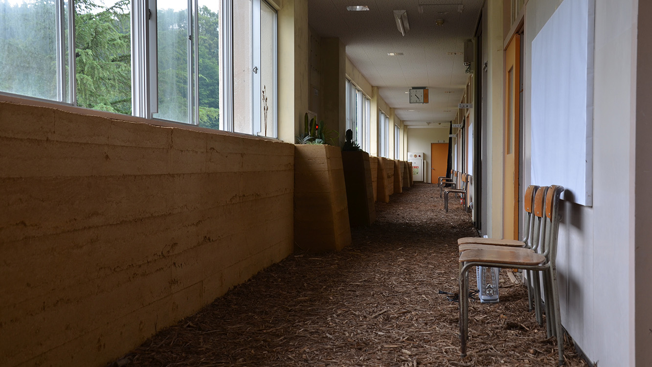 約30m続く低い版築の壁。膨大な作業量に向き合いながら素材の個性を引き出した。