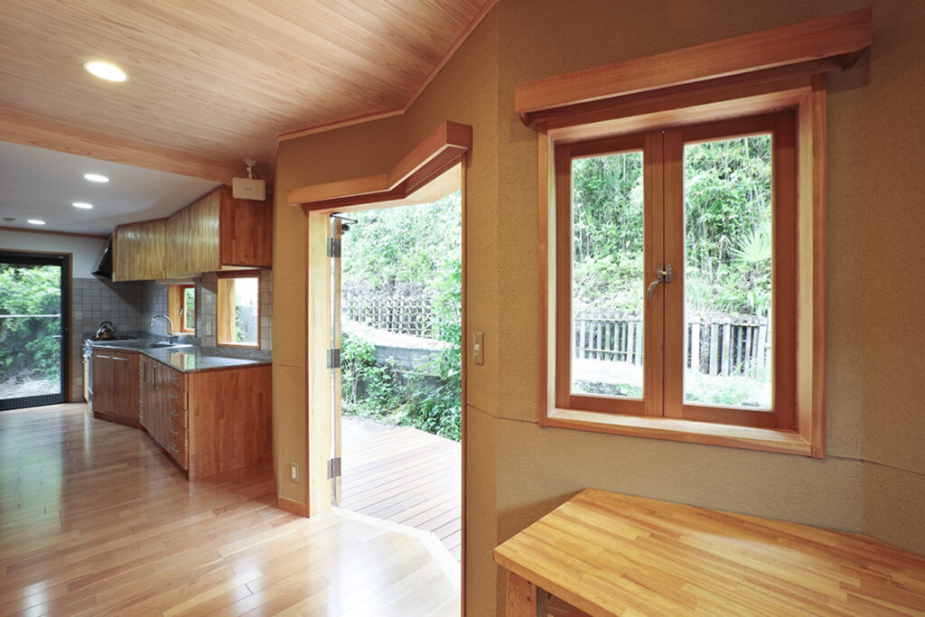 折れ壁に合わせて製作した木製窓が、室内外をシームレスにつなぐ。