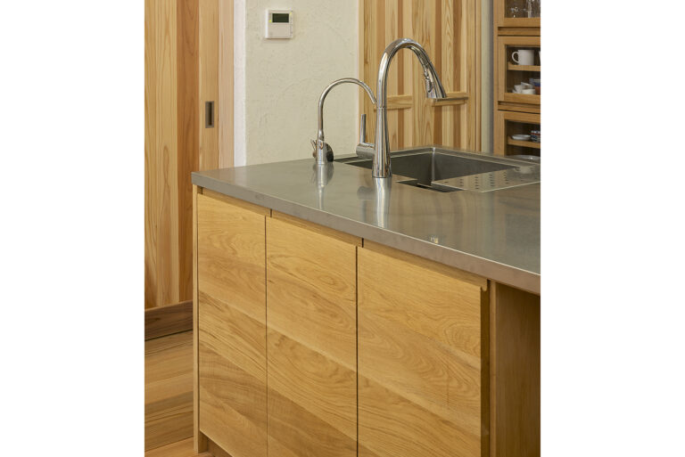 ナラ材を中心に特注製作したキッチン。杉天井や漆喰と自然に調和。