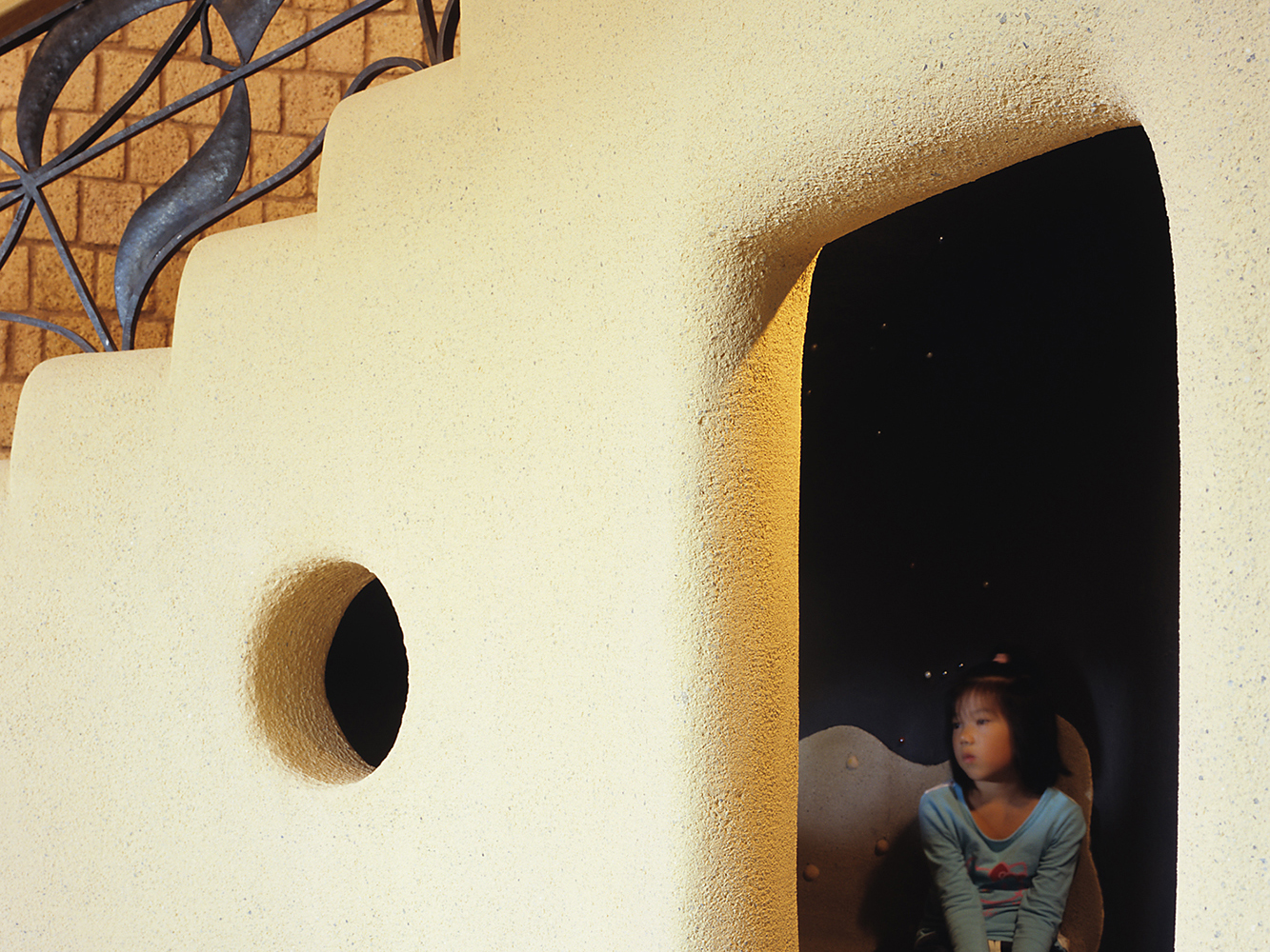 2階へ続くウェーブ状の階段。下部には子供の“ほら穴”空間。