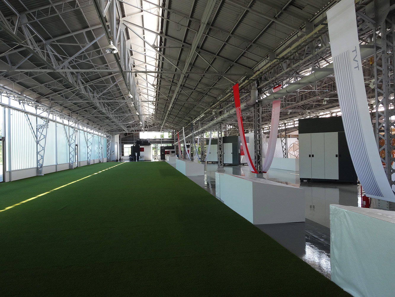 無機質だった工場を、明るさと回遊性を重視した展示空間として再構築。展示会・新製品発表にも対応できる汎用的なレイアウト。