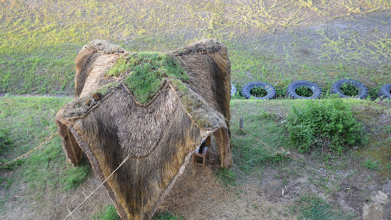 茅葺きの小屋。かつての技術者の労力と知恵に思いを馳せる象徴的な造形。